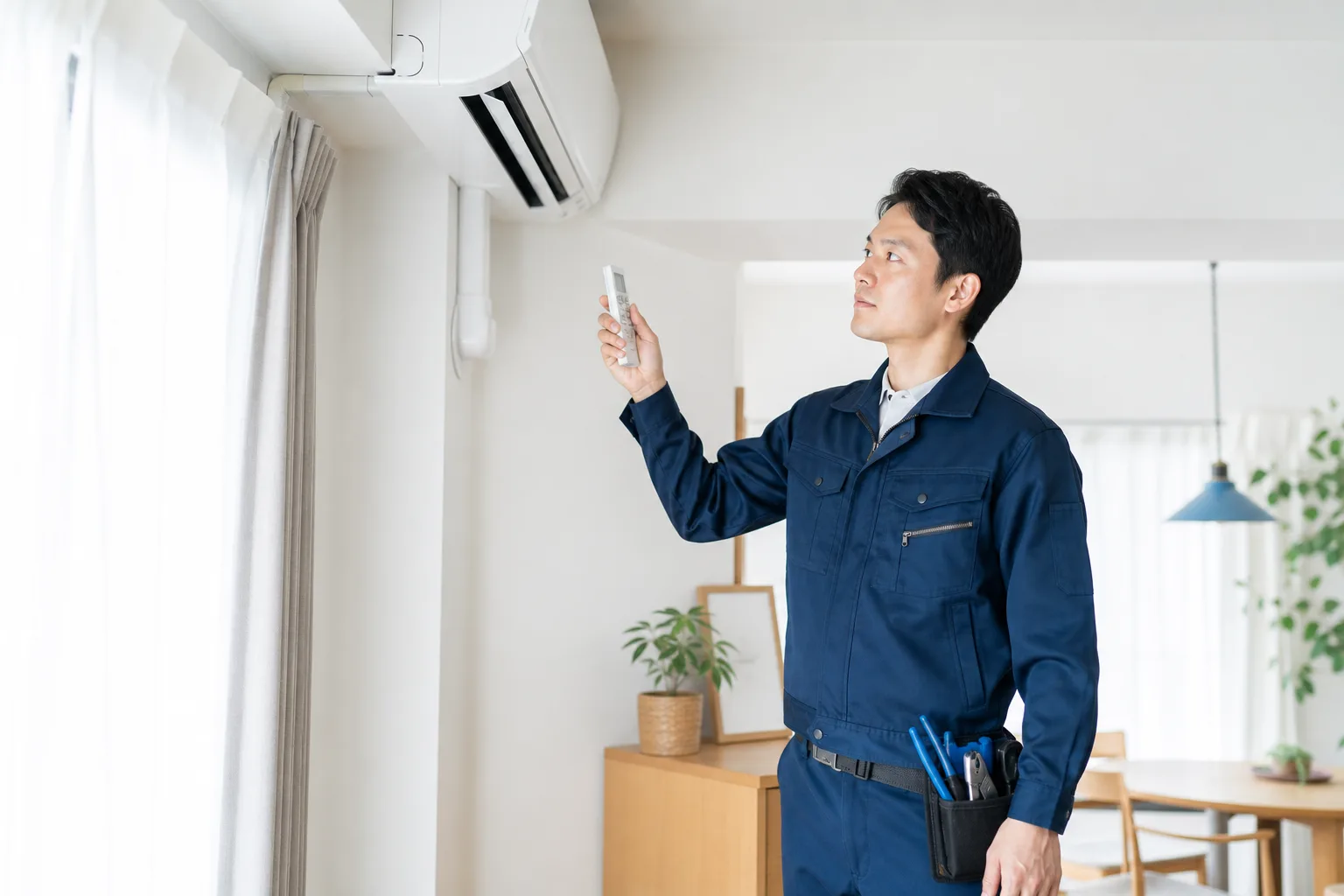 室内エアコンを確認する空調設備スタッフ
