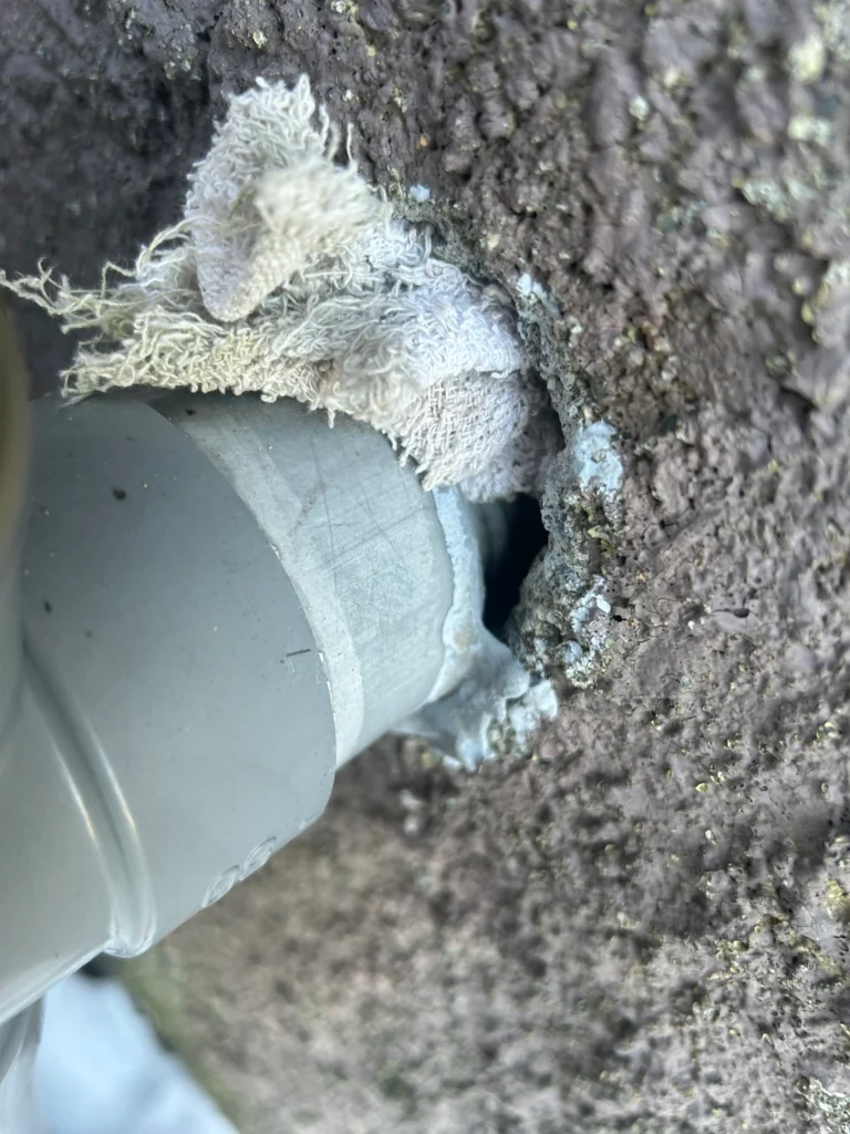 キッチン下蛇腹ホースを無理くり突っ込んでいる状態かつ隙間が確認できる写真