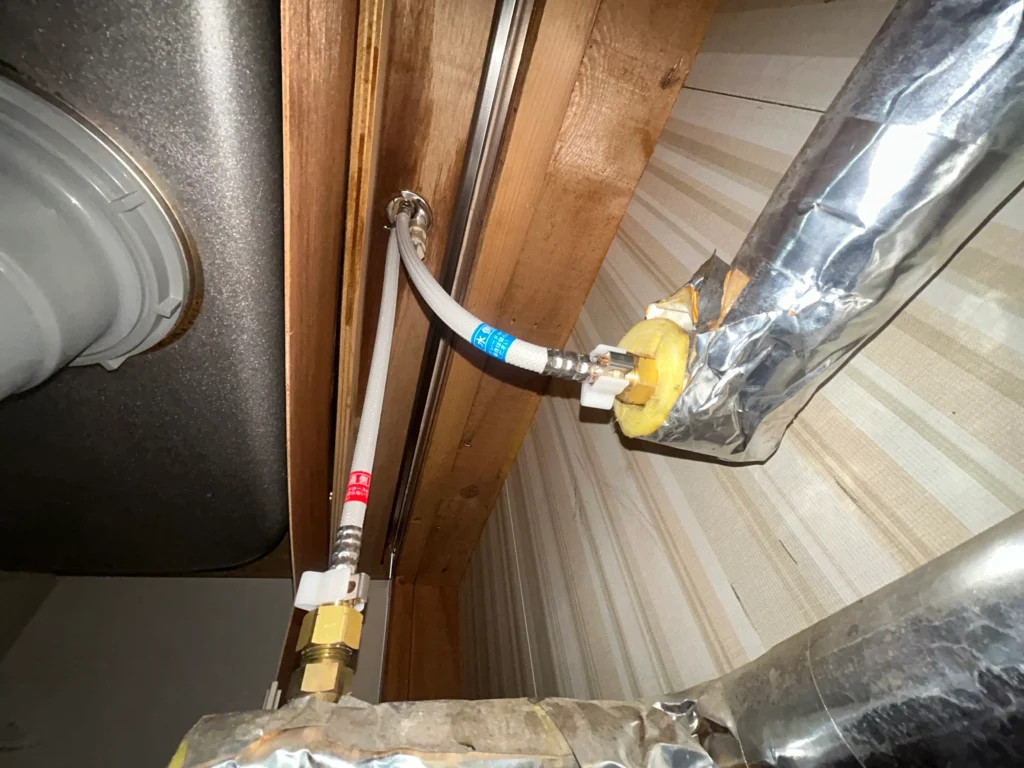 凍結破損によるキッチン（台所）混合栓取替工事中の給水管、給湯管の接続時写真